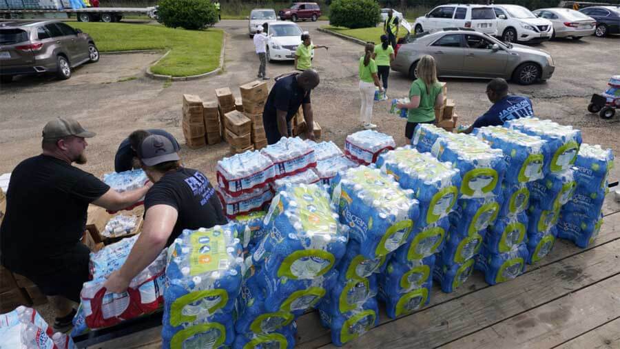 Firefighters and Humana volunteers distribute water and food on September 2, 2022, in Jackson, Mississippi. Photo, Steve Helber/AP