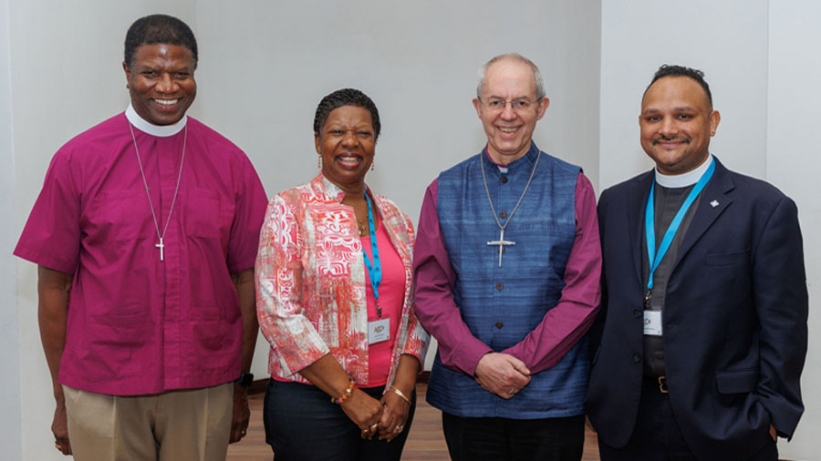 The Episcopal Church’s delegation to the 18th Anglican Consultative Council (ACC) — Maryland Bishop Eugene Sutton, Annette Buchanan, a lay leader from the Diocese of New Jersey, and the Rev. Ranjit Mathews, the Diocese of Connecticut’s canon for mission, advocacy, racial justice and reconciliation — poses with Archbishop of Canterbury Justin Welby on Feb. 14 in Accra, Ghana, where the Feb. 12-19 meeting is underway. Photo: Neil Turner for the Anglican Communion Office