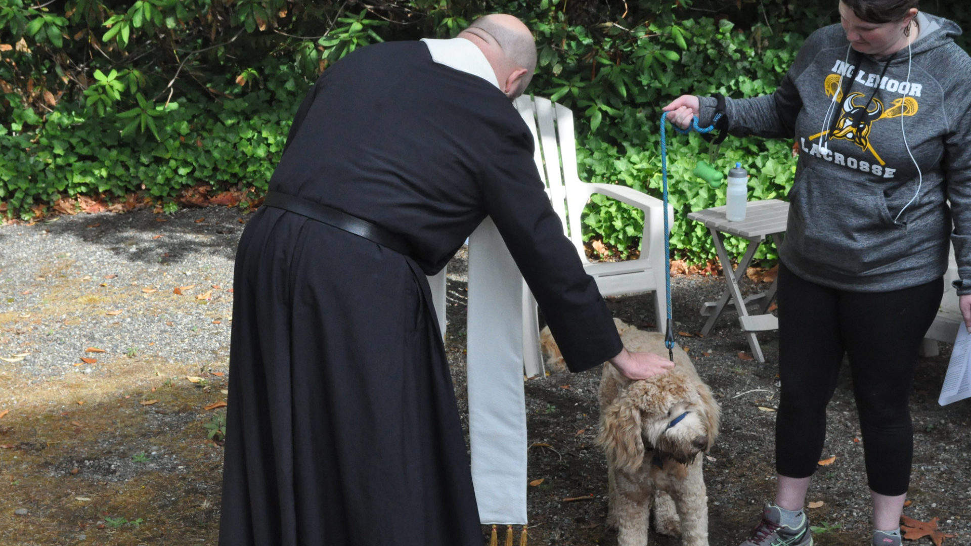 Father Jed blessing a dog at the Redeemer campus.