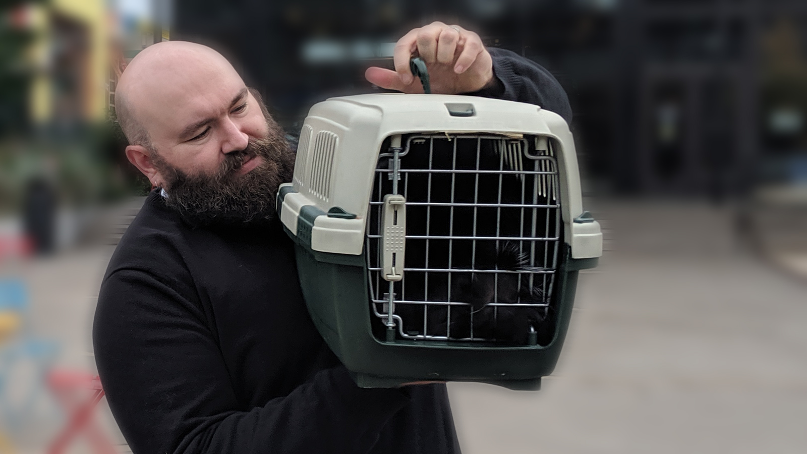 Father Jed blessing a cat in a carrier at Kenmore Town Square.